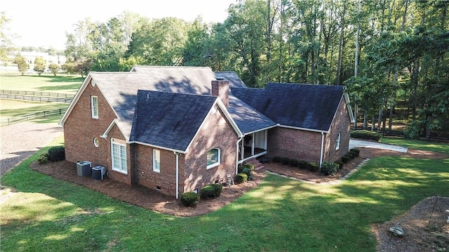 view of side of home featuring a yard and central AC