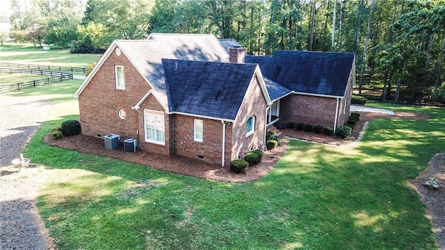 view of home's exterior with a lawn and central AC