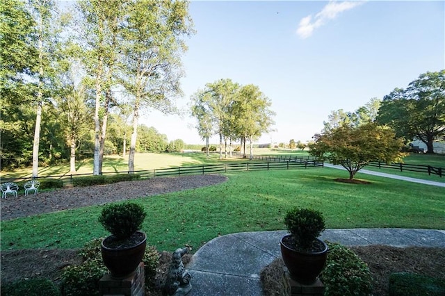 view of community featuring a lawn and a rural view