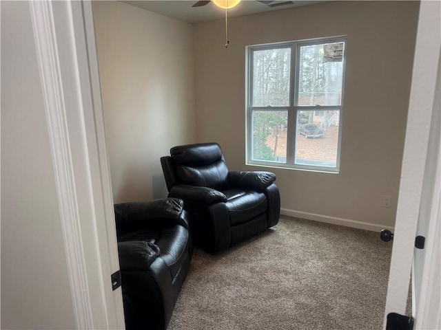 sitting room with carpet floors, baseboards, and a ceiling fan