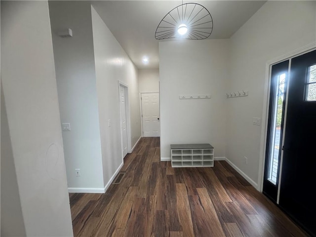 foyer with dark wood-style floors, visible vents, and baseboards