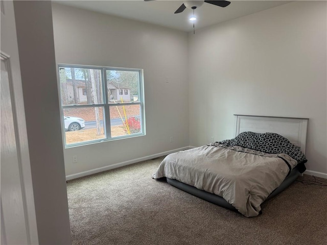 bedroom with a ceiling fan, carpet flooring, and baseboards