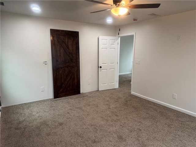 unfurnished bedroom with a ceiling fan, carpet, visible vents, and baseboards