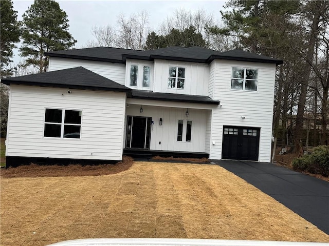 modern farmhouse with driveway, board and batten siding, and an attached garage