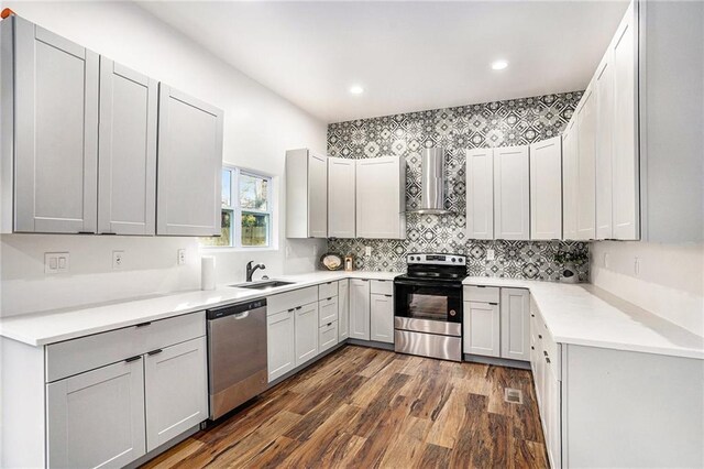 kitchen with electric range, a sink, open floor plan, gray cabinets, and wall chimney exhaust hood