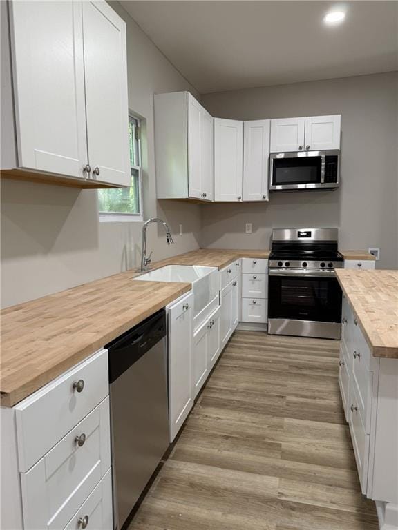 1300 Murphy Ave, Lagrange, GA 30240 - kitchen featuring appliances with stainless steel finishes, butcher block countertops, a sink, white cabinetry, and recessed lighting