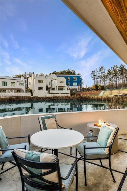 balcony featuring a water view and a fire pit