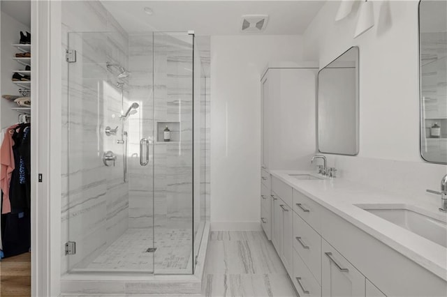 bathroom with a shower with door and vanity