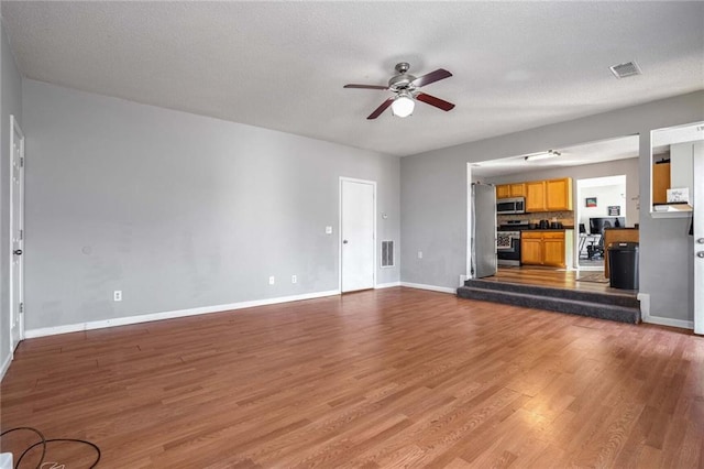 unfurnished living room with wood-type flooring and ceiling fan