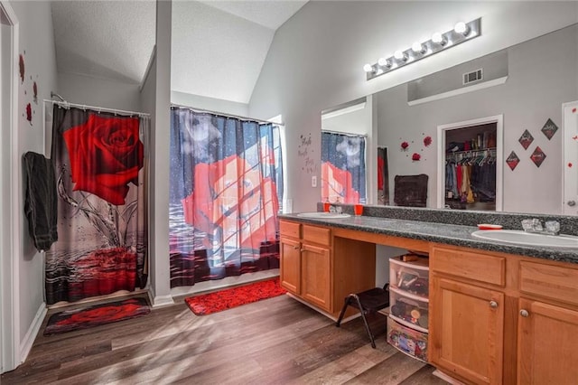 bathroom with vanity, lofted ceiling, wood-type flooring, and a shower with shower curtain