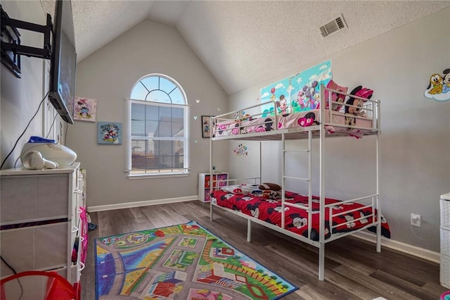 bedroom with vaulted ceiling, hardwood / wood-style floors, and a textured ceiling