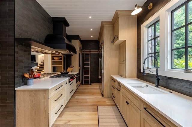 170 Autry Trl, Johns Creek, GA 30022 - kitchen featuring stainless steel gas stovetop, light wood-style flooring, exhaust hood, light countertops, and a barn door