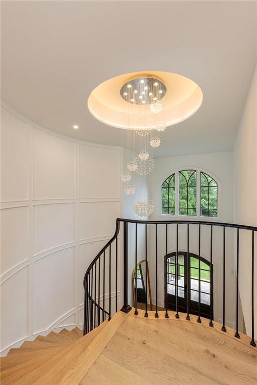 170 Autry Trl, Johns Creek, GA 30022 - stairs featuring wood finished floors, a raised ceiling, a chandelier, and a decorative wall