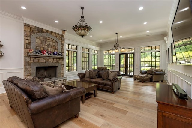 170 Autry Trl, Johns Creek, GA 30022 - living room with crown molding, a decorative wall, a fireplace, wainscoting, and light wood finished floors
