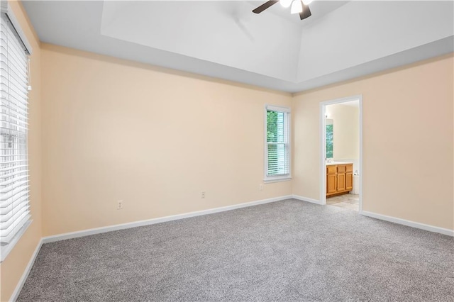 empty room with ceiling fan, light carpet, and baseboards