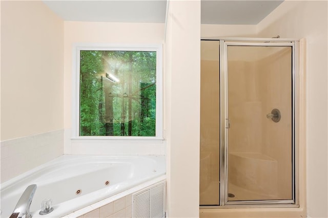 full bath featuring a jetted tub and a stall shower