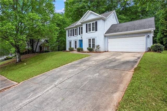 colonial inspired home featuring roof with shingles, an attached garage, driveway, and a front lawn