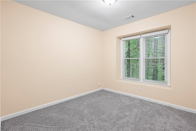 carpeted empty room featuring baseboards and visible vents