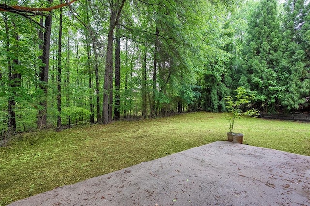 view of yard with a forest view and a patio area