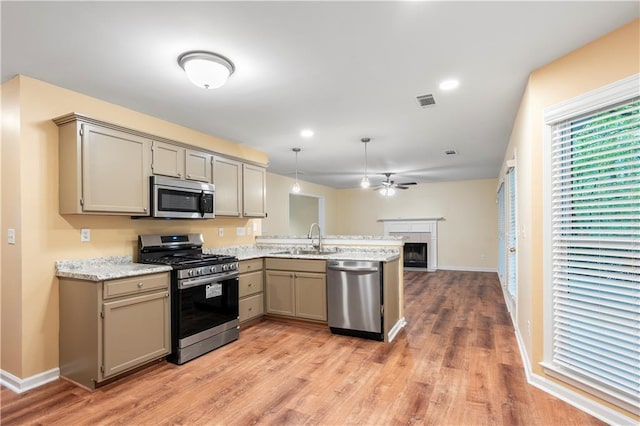 kitchen with a sink, gray cabinetry, stainless steel appliances, and a peninsula