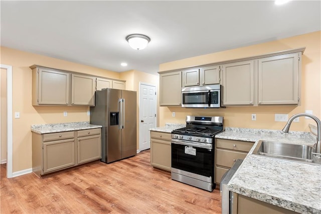 kitchen with light wood-style floors, light countertops, a sink, gray cabinetry, and stainless steel appliances