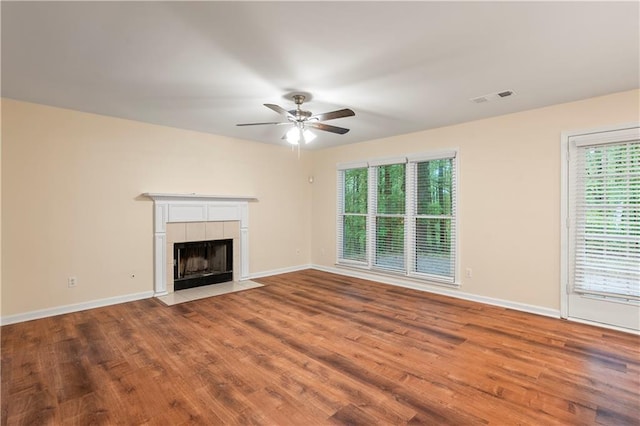 unfurnished living room with baseboards, ceiling fan, visible vents, and wood finished floors