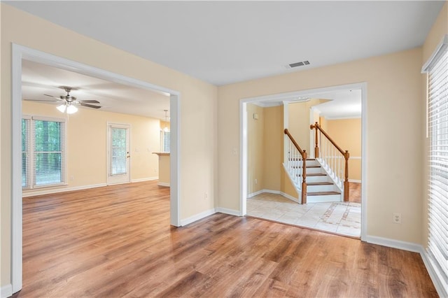 unfurnished room with visible vents, baseboards, ceiling fan, and light wood-type flooring
