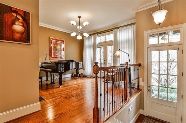 entryway with crown molding, wood-type flooring, and plenty of natural light