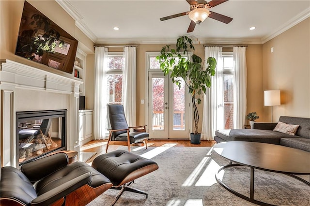 sitting room with french doors, ceiling fan, crown molding, and light hardwood / wood-style flooring