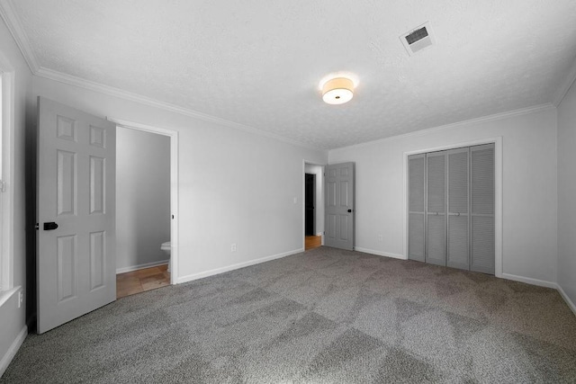 unfurnished bedroom with carpet, a closet, visible vents, and crown molding