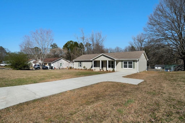 ranch-style home with concrete driveway and a front lawn