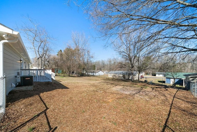 view of yard featuring central air condition unit and fence