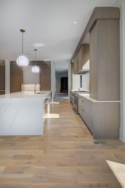 kitchen featuring stainless steel range with gas cooktop, light countertops, and modern cabinets