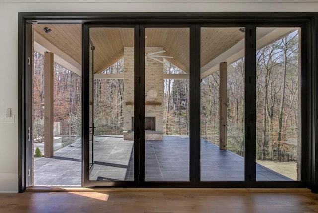 doorway featuring lofted ceiling, wooden ceiling, floor to ceiling windows, and wood finished floors