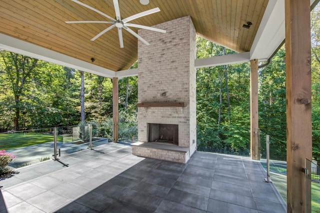 view of patio with an outdoor brick fireplace and a ceiling fan