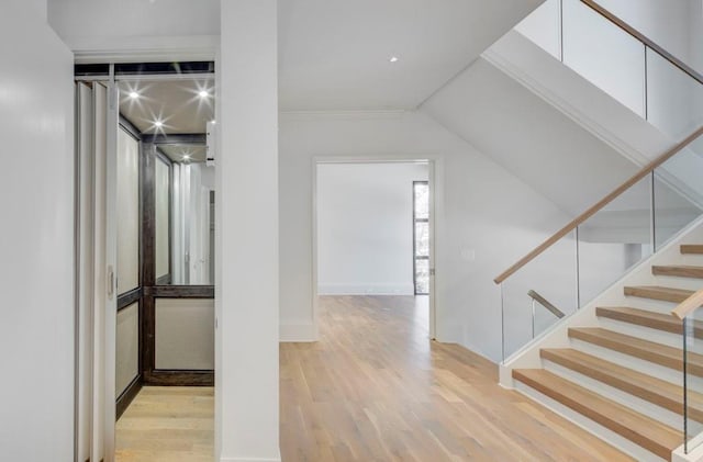 hallway with stairway, baseboards, and wood finished floors