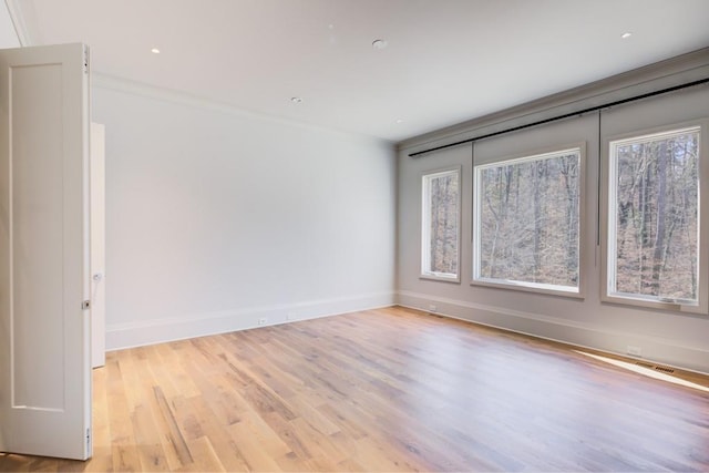 unfurnished room with recessed lighting, ornamental molding, light wood finished floors, baseboards, and visible vents