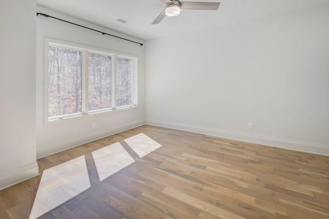 unfurnished room featuring baseboards, ceiling fan, visible vents, and light wood finished floors