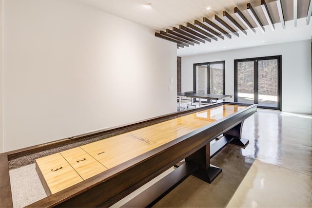 playroom featuring concrete floors, french doors, and baseboards