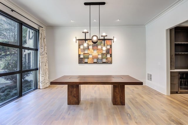 unfurnished dining area featuring visible vents, wood finished floors, crown molding, and wine cooler