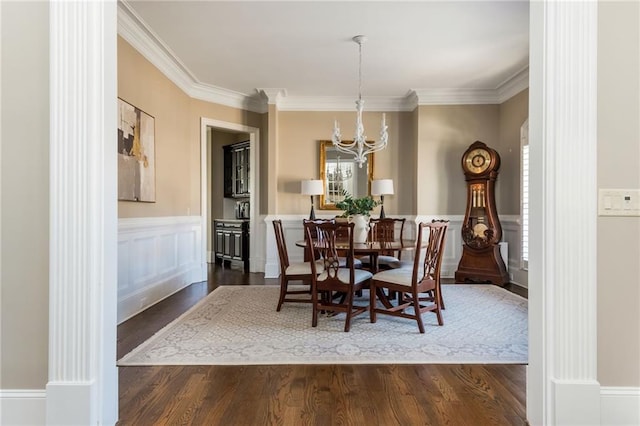 dining space featuring dark wood-style floors, ornamental molding, and wainscoting