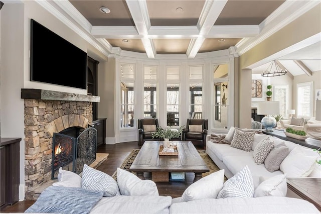 living area featuring crown molding, dark wood-style flooring, beamed ceiling, and a stone fireplace