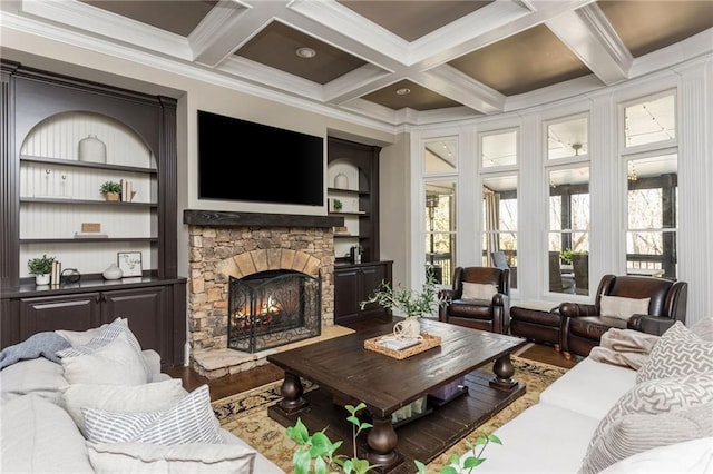 living area with a wealth of natural light, a fireplace, beamed ceiling, and wood finished floors