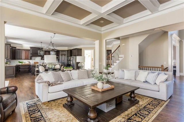 living room featuring stairs, coffered ceiling, dark wood-style flooring, and beamed ceiling