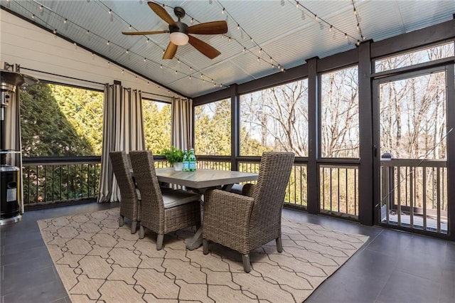 sunroom / solarium featuring a healthy amount of sunlight, ceiling fan, and vaulted ceiling