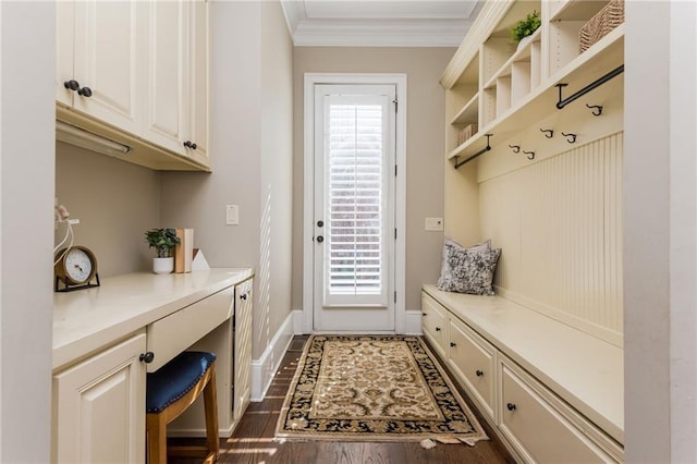 mudroom with ornamental molding, dark wood-style flooring, built in study area, and a healthy amount of sunlight