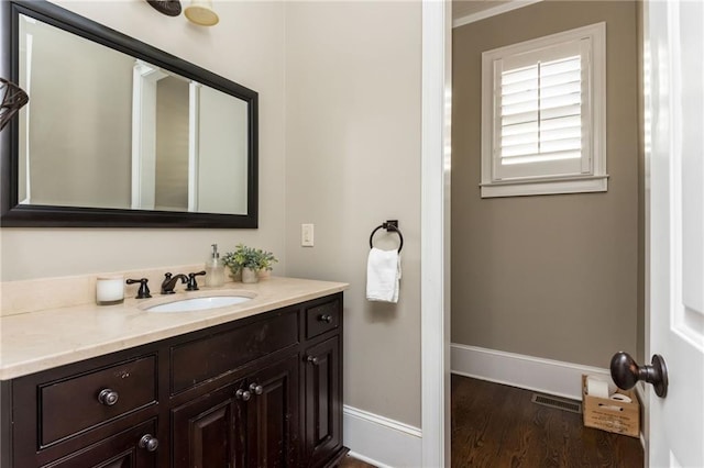 bathroom with wood finished floors, vanity, and baseboards