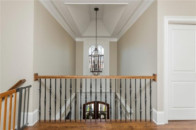 stairs featuring baseboards, lofted ceiling, ornamental molding, wood finished floors, and a notable chandelier