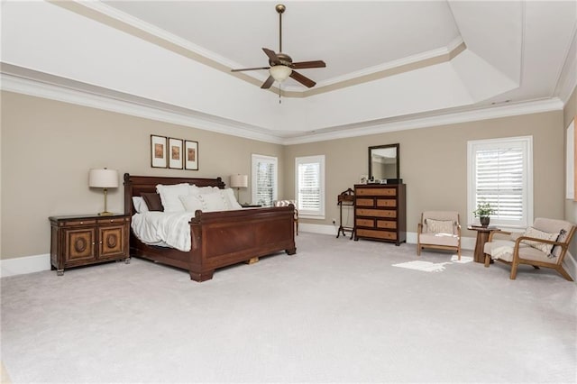 bedroom with multiple windows, a tray ceiling, ornamental molding, and light colored carpet