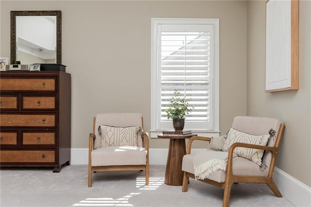 sitting room featuring light carpet and baseboards